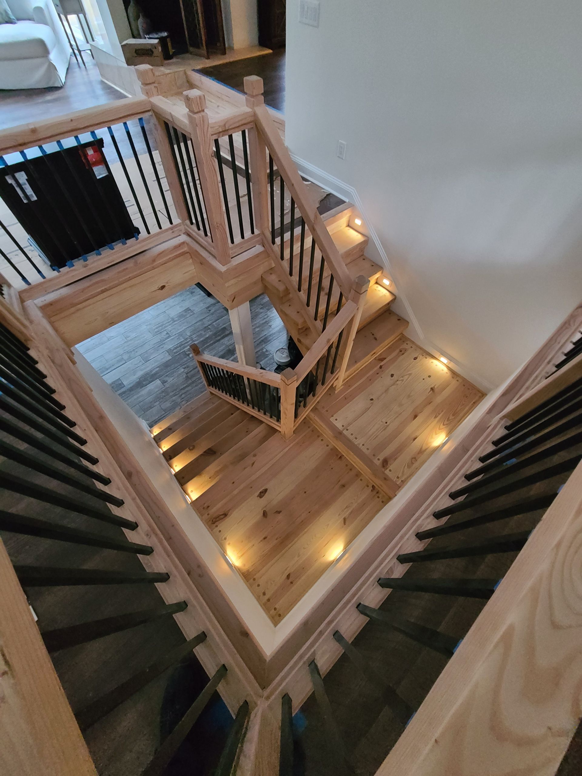 A wooden staircase with lights on the steps in a house.