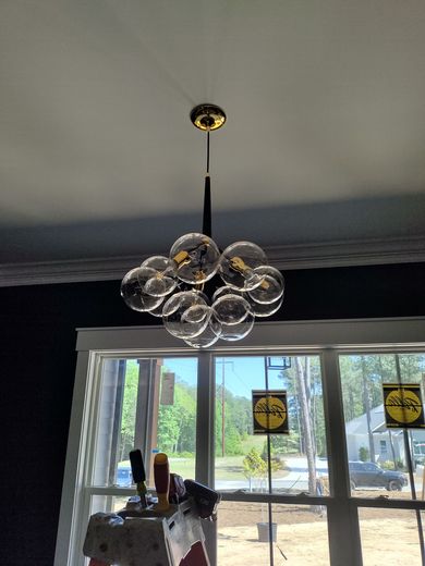 A chandelier is hanging from the ceiling in front of a window