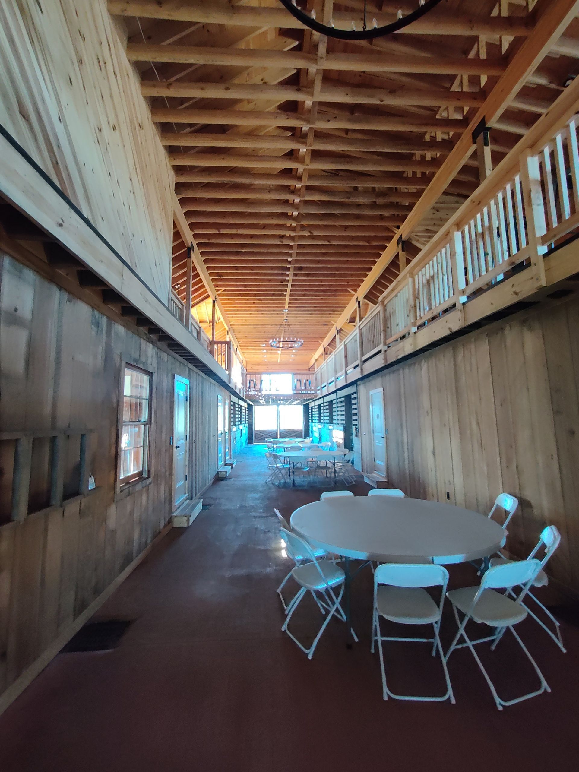 A long hallway with tables and chairs in it