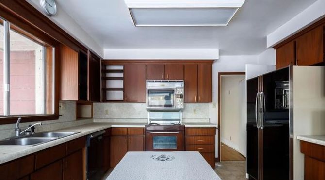 Modern kitchen with dark wood cabinets, stainless steel appliances, and a central island