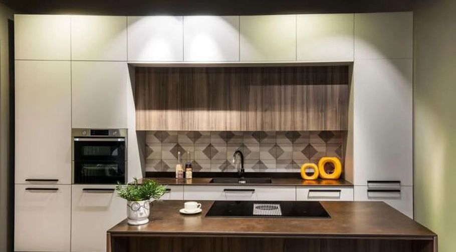Modern kitchen with white cabinets, wood island, patterned backsplash, and built-in oven
