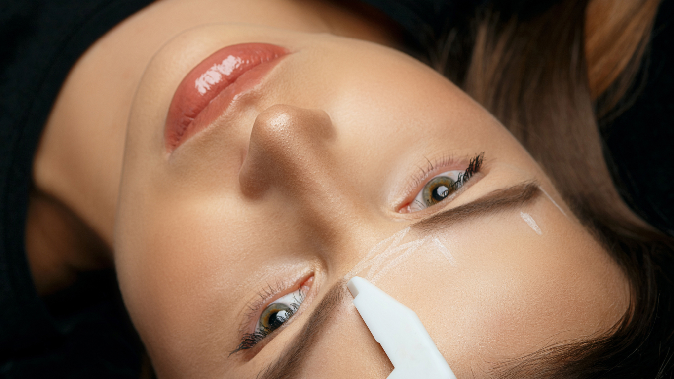 a woman is laying down with a needle in her eye .