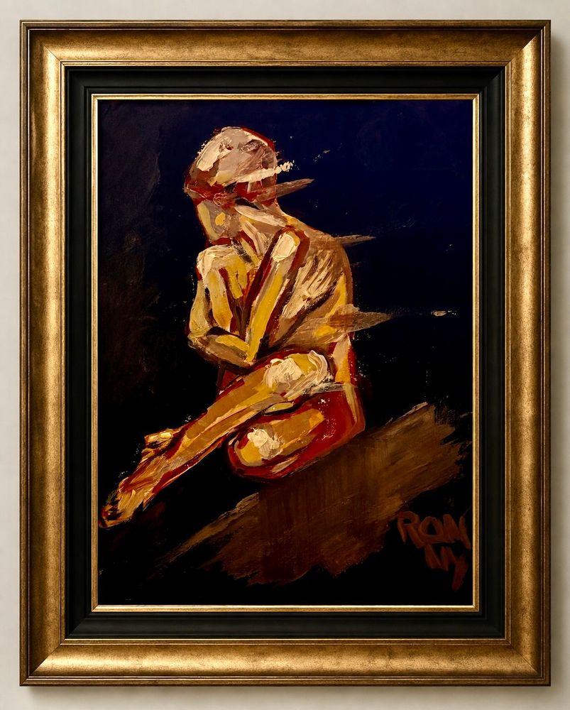 Ingelijst abstract schilderij van een zittende figuur in goud en bruin tegen een donkerblauwe achtergrond.