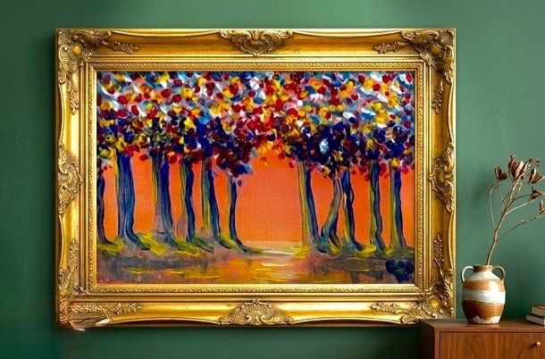 Abstracte, kleurrijke boomschilderij in een sierlijke gouden lijst aan een groene muur, naast een kleine vaas op een tafel.
