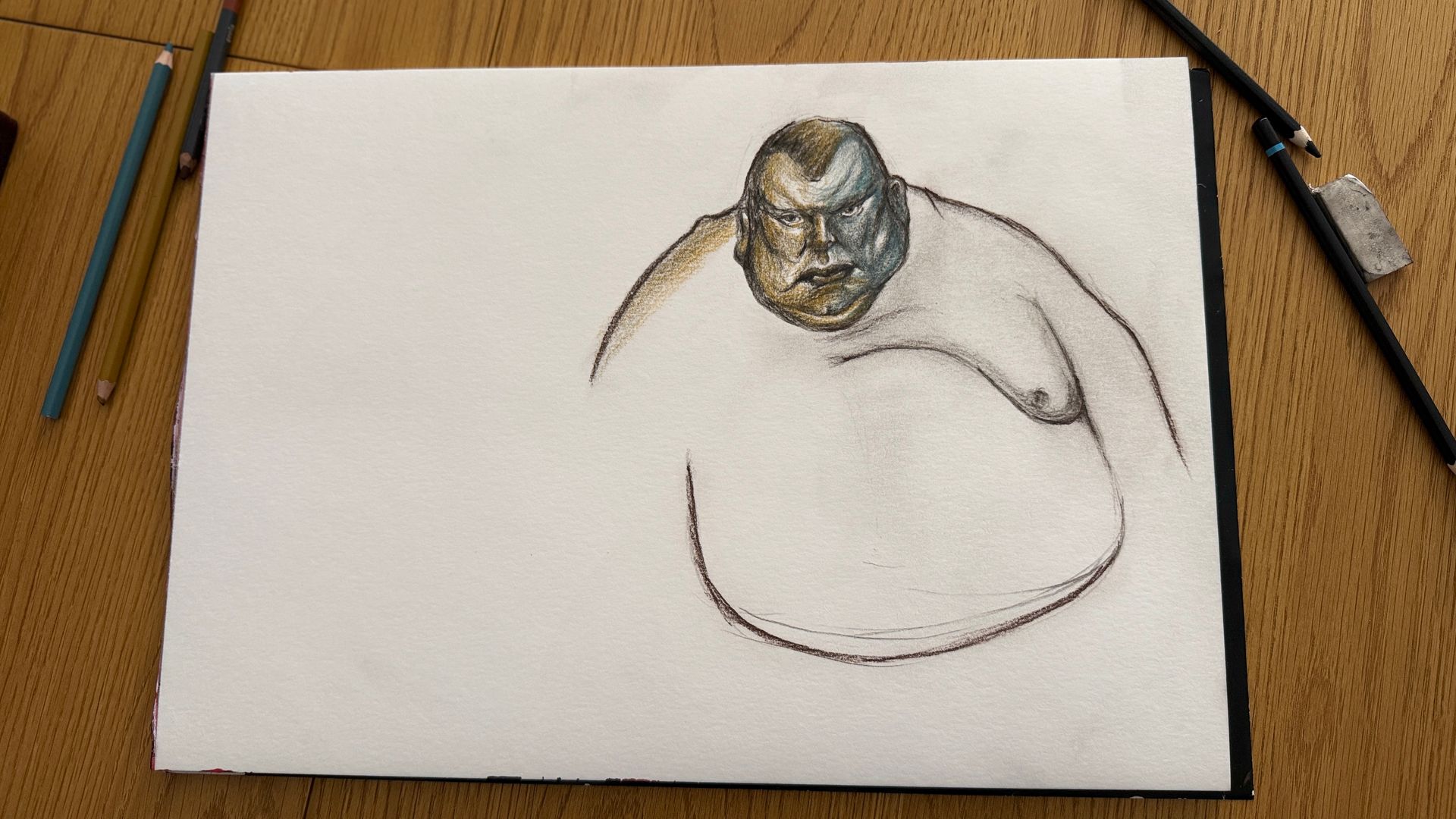 Schets van een grijs-witte kat op wit papier, met potloden en een gum, op een houten tafel.