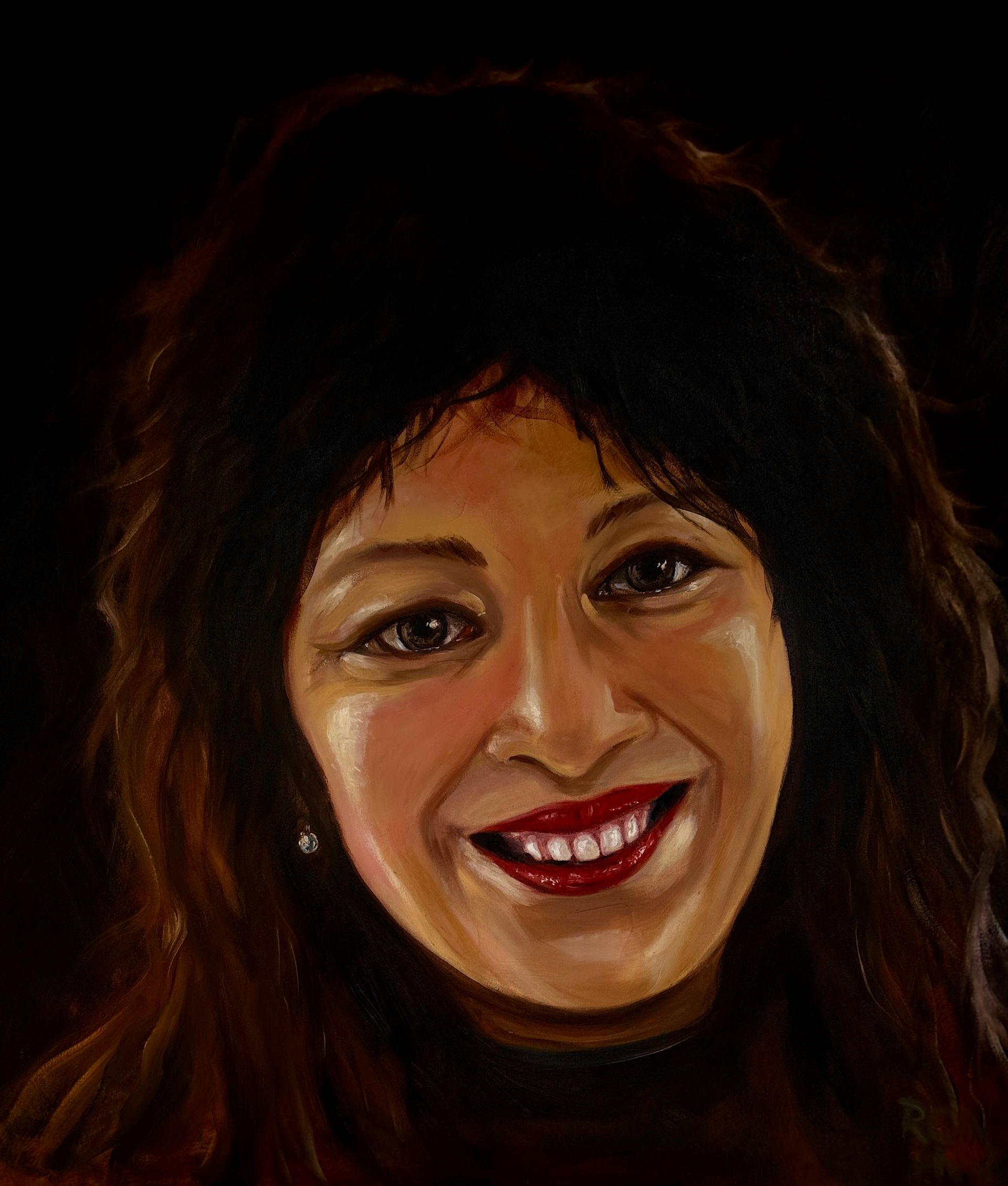 Portret van een lachende vrouw met donker haar en rode lippenstift op een donkere achtergrond.