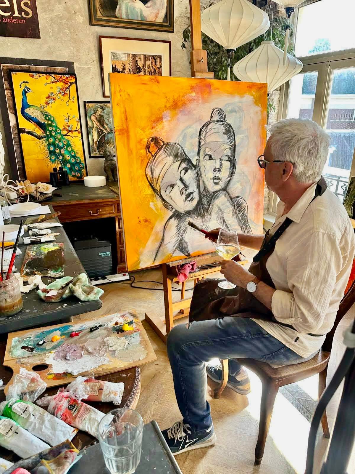 Een kunstenaar schildert een portret aan een schildersezel in een lichte studio, omringd door schildersbenodigdheden en kunstwerken.