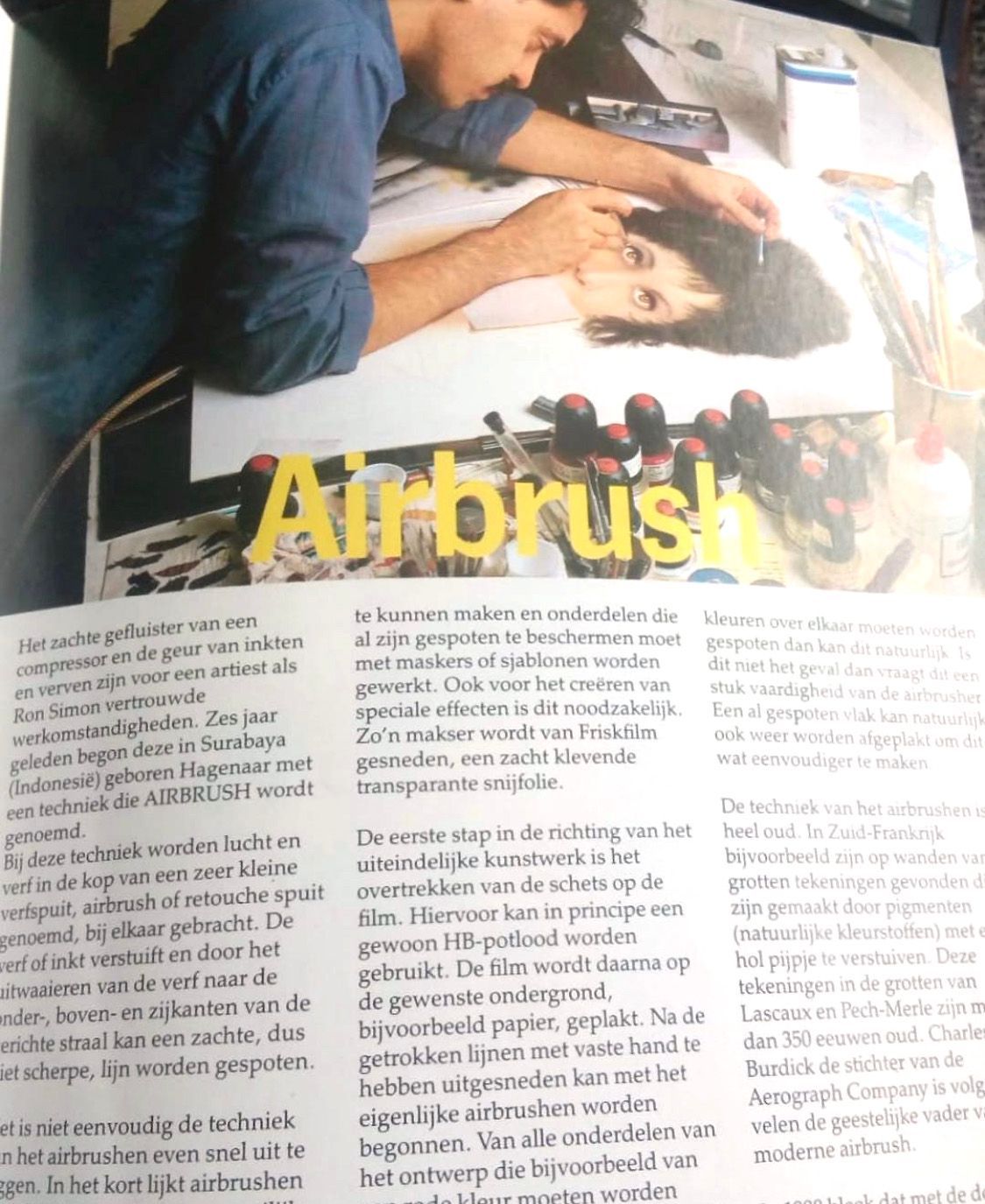Tijdschriftpagina waarop iemand te zien is die met een airbrush kunst op papier aanbrengt, met het woord 'Airbrush' eroverheen.
