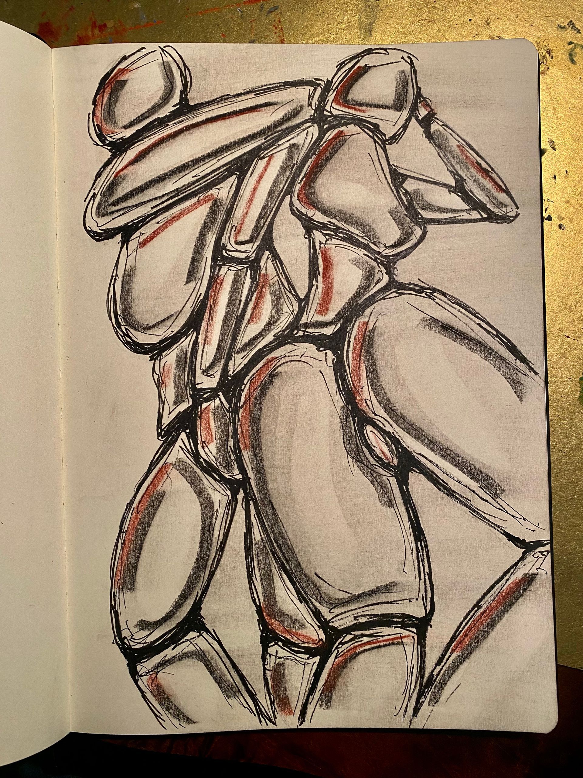 Abstracte schets van twee figuren in zwart en rood op een open schetsboekpagina.