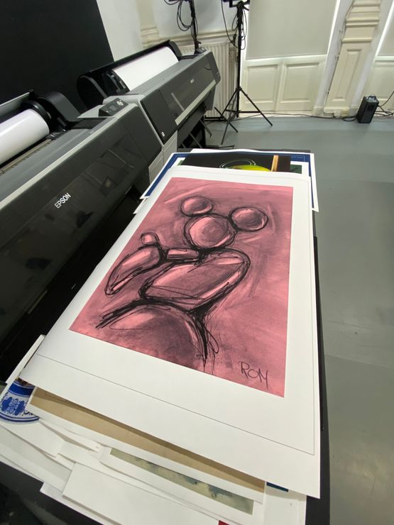 Een printer toont een abstracte schets in roze tinten op groot wit papier in een studio-achtige ruimte.