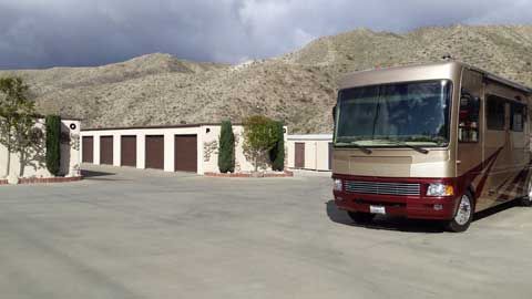 A large rv is parked in a parking lot in front of a building.