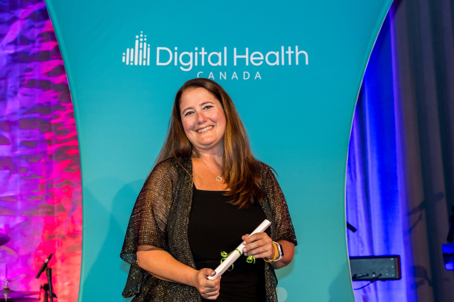 A woman is holding a certificate in front of a digital health canada banner.