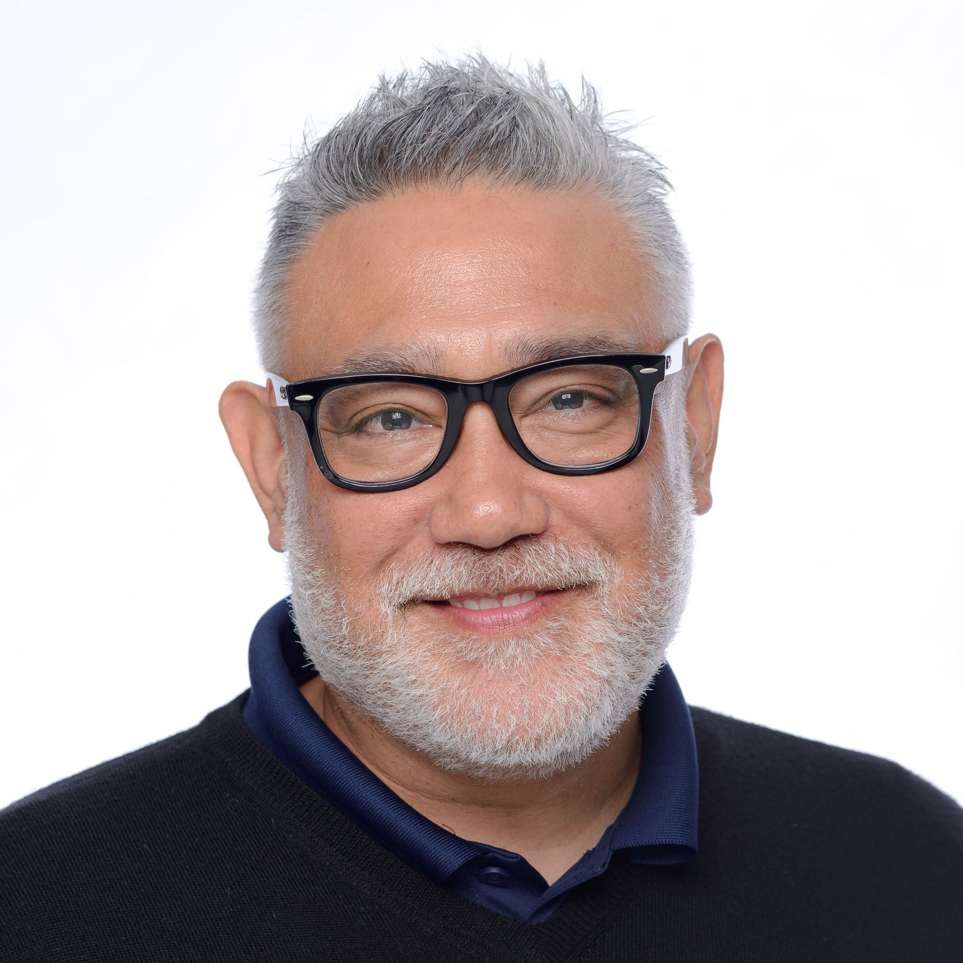 A man with a beard and glasses is wearing a suit and tie.