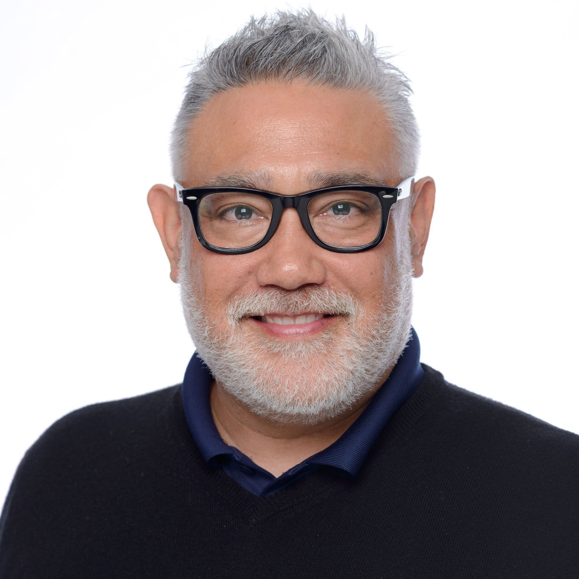 A man with a beard and glasses is wearing a suit and tie.