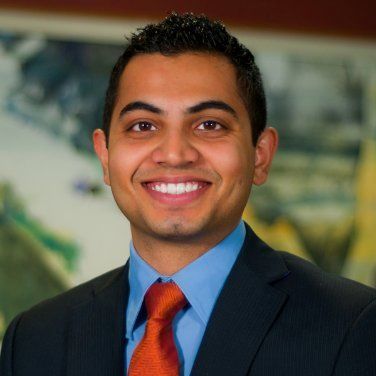 A man in a suit and tie is smiling for the camera.