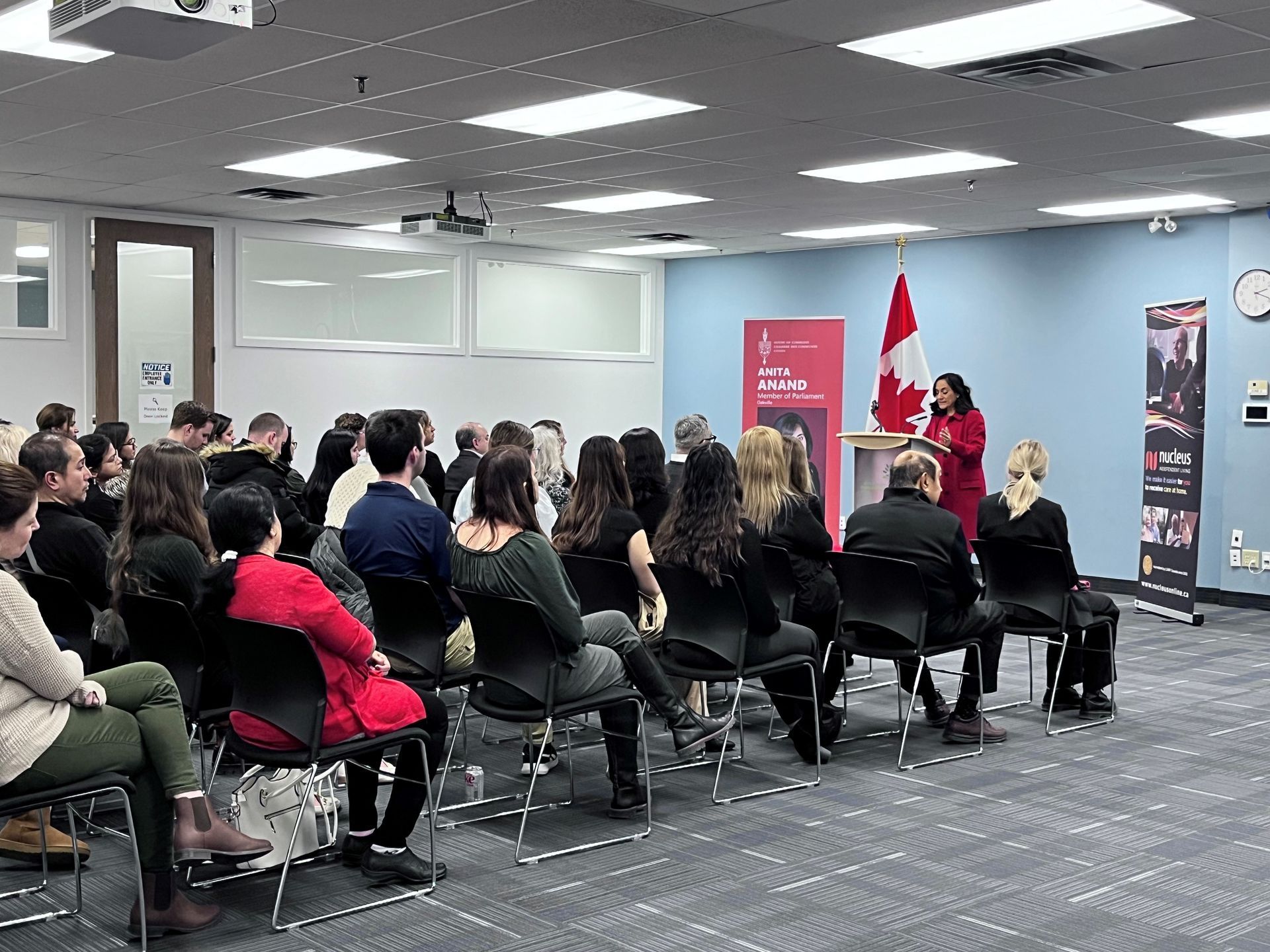 A woman is giving a presentation to a group of people sitting in chairs.