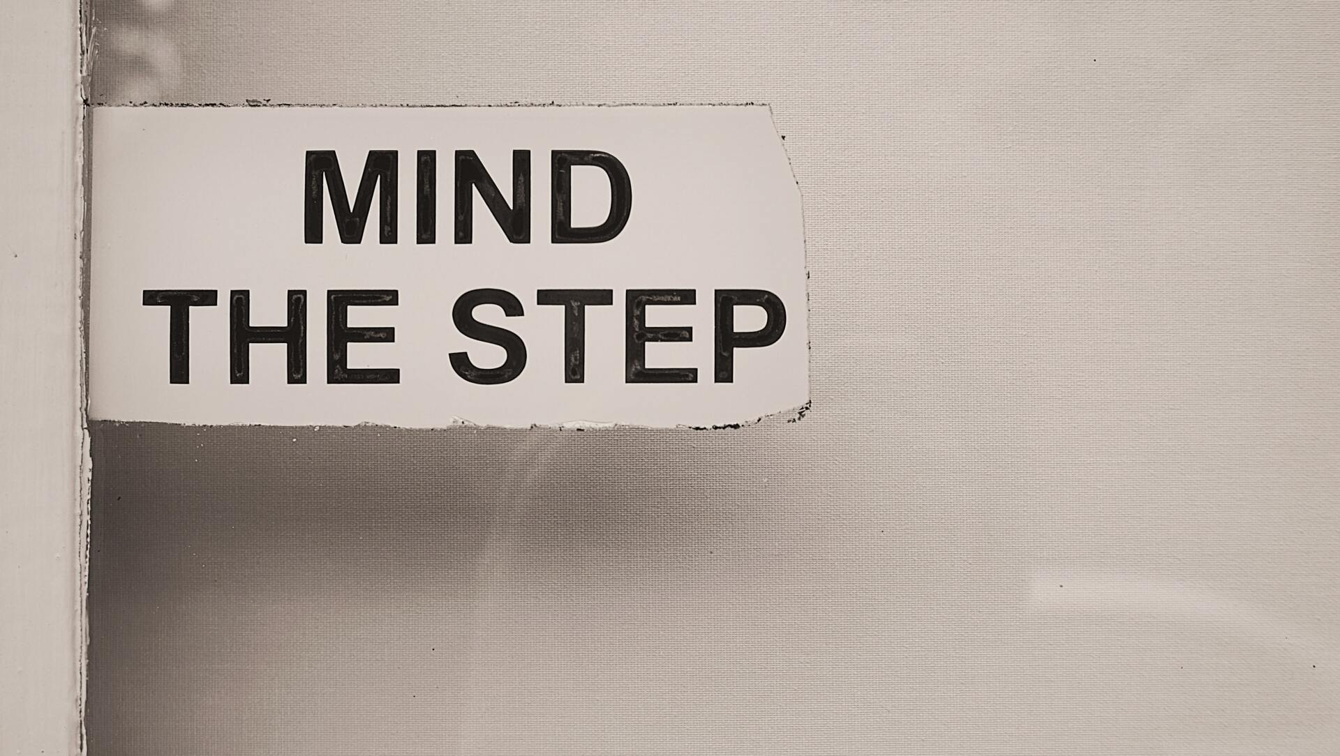 A sign on a wall that says `` mind the step ''