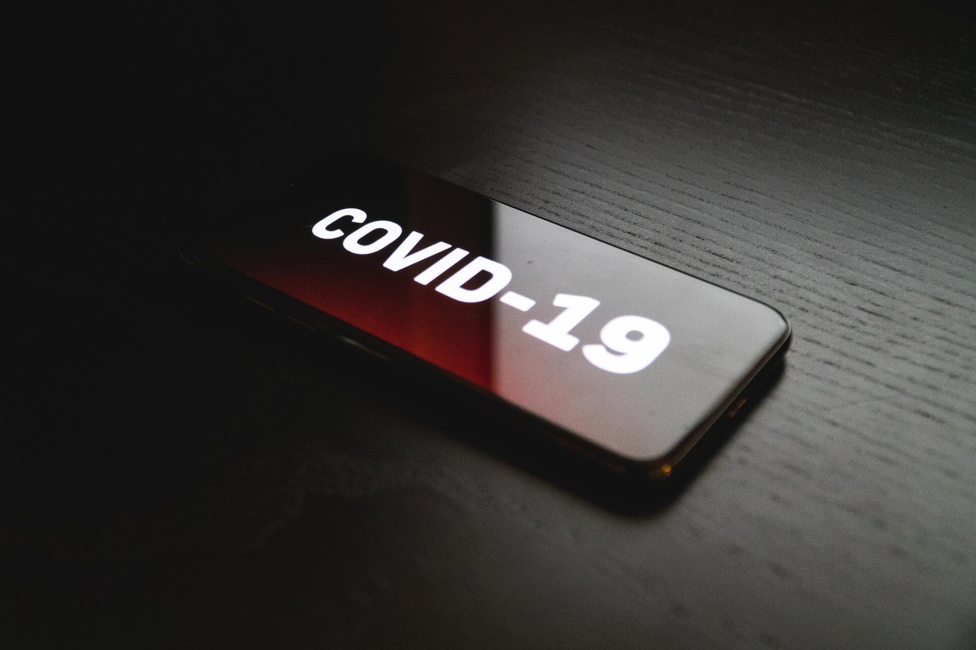 A cell phone with the word covid-19 on it