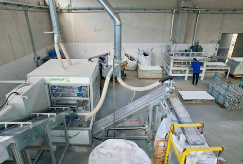 Pannelli solari impilati con cornice blu in un magazzino o in un deposito.
