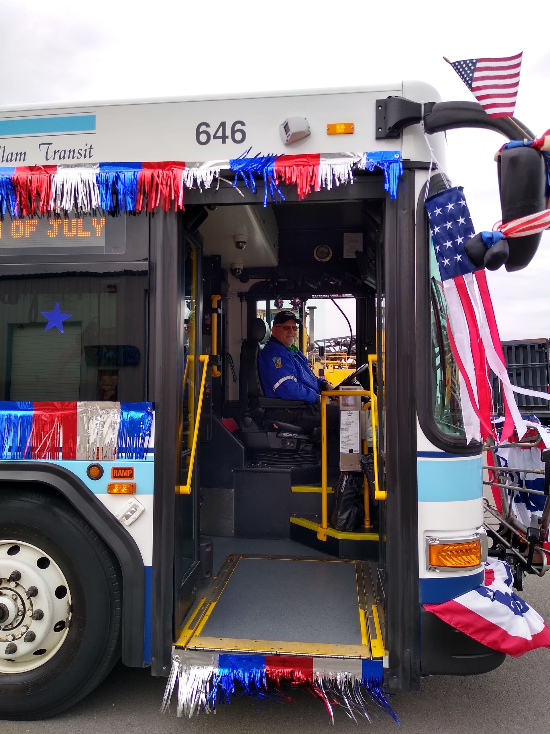 Transit operator sitting in a bus that is decorated in red, white, and blue for the Fourth of July.