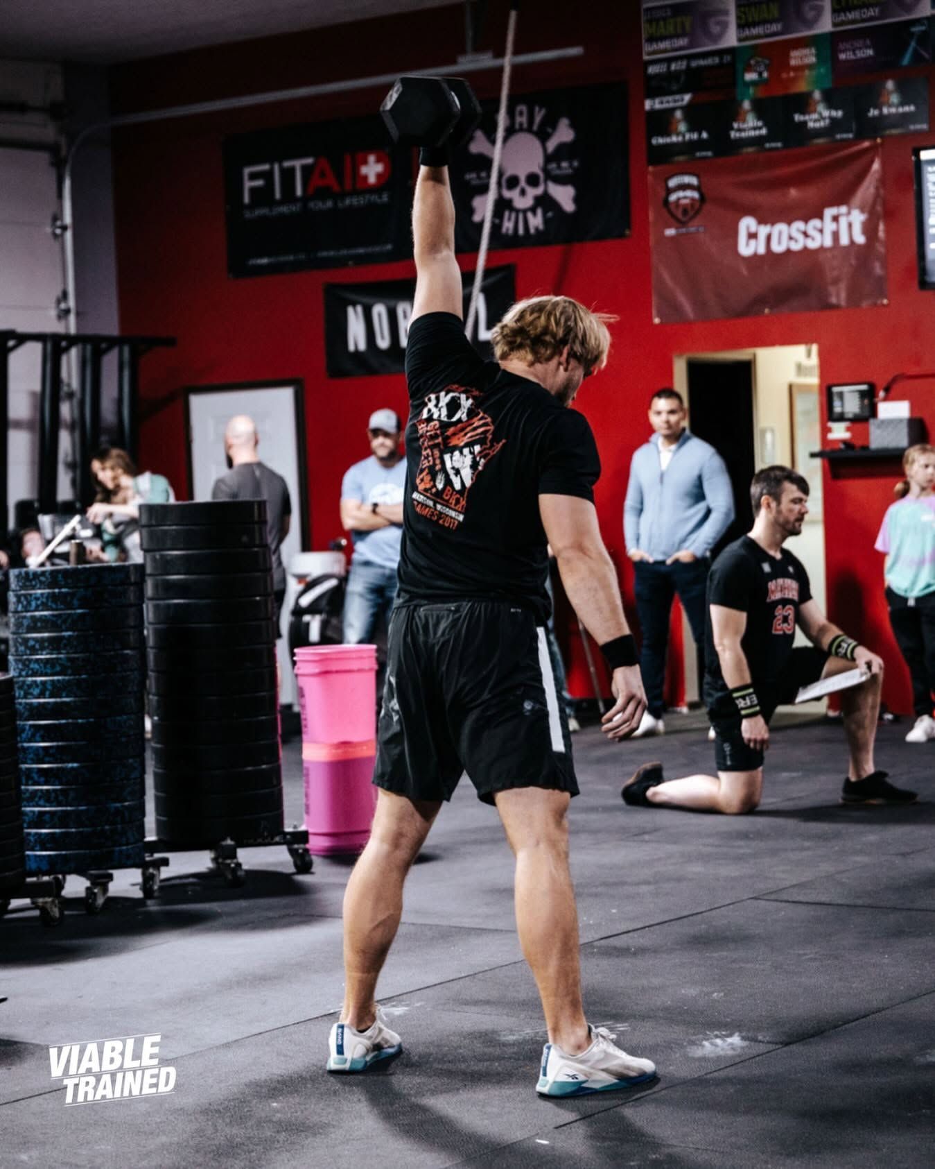 Man rowing on an indoor rowing machine outdoors, wearing a green shirt and gray shorts at the best CrossFit gym in Sioux Falls, SD.