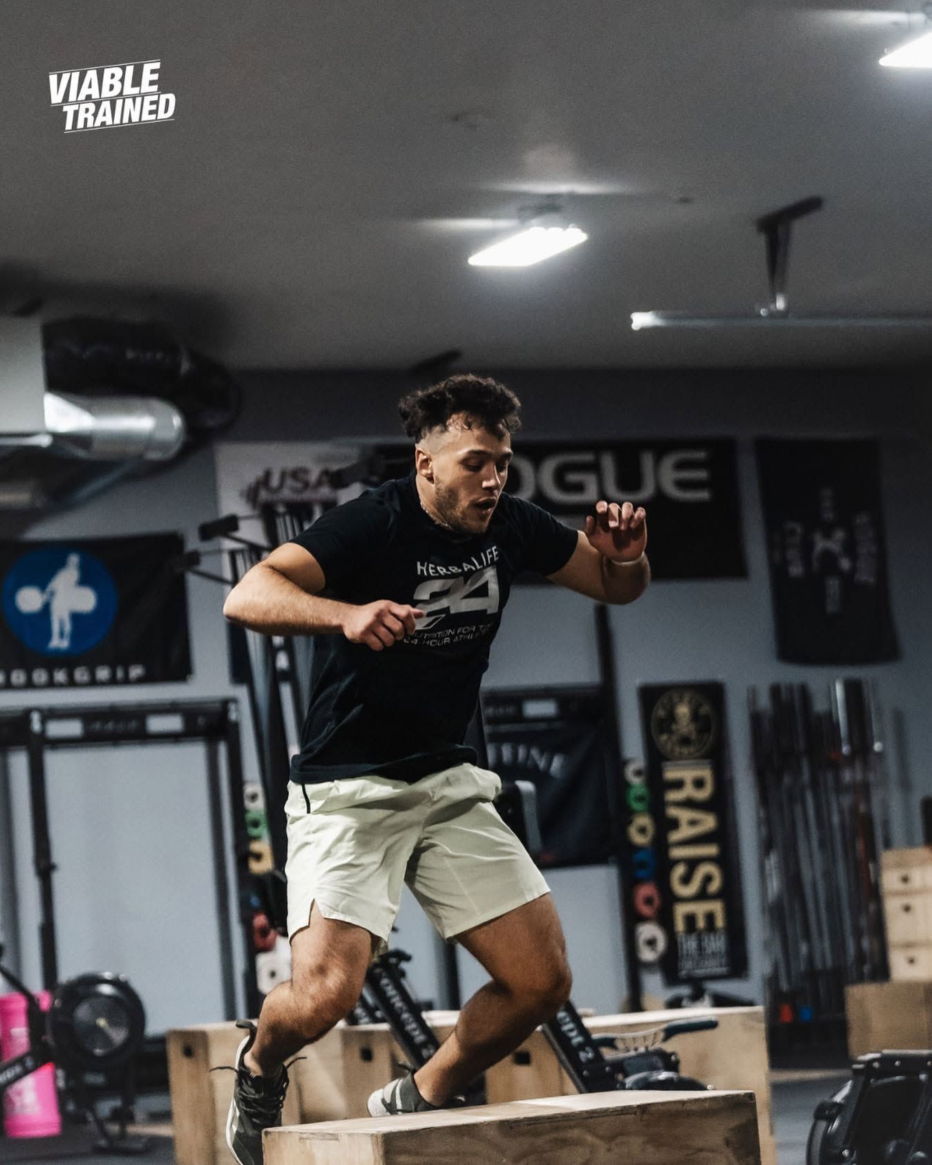 Person riding a low, wheeled cart on a street, with parked cars in the background at the best CrossFit gym in Sioux Falls, SD.