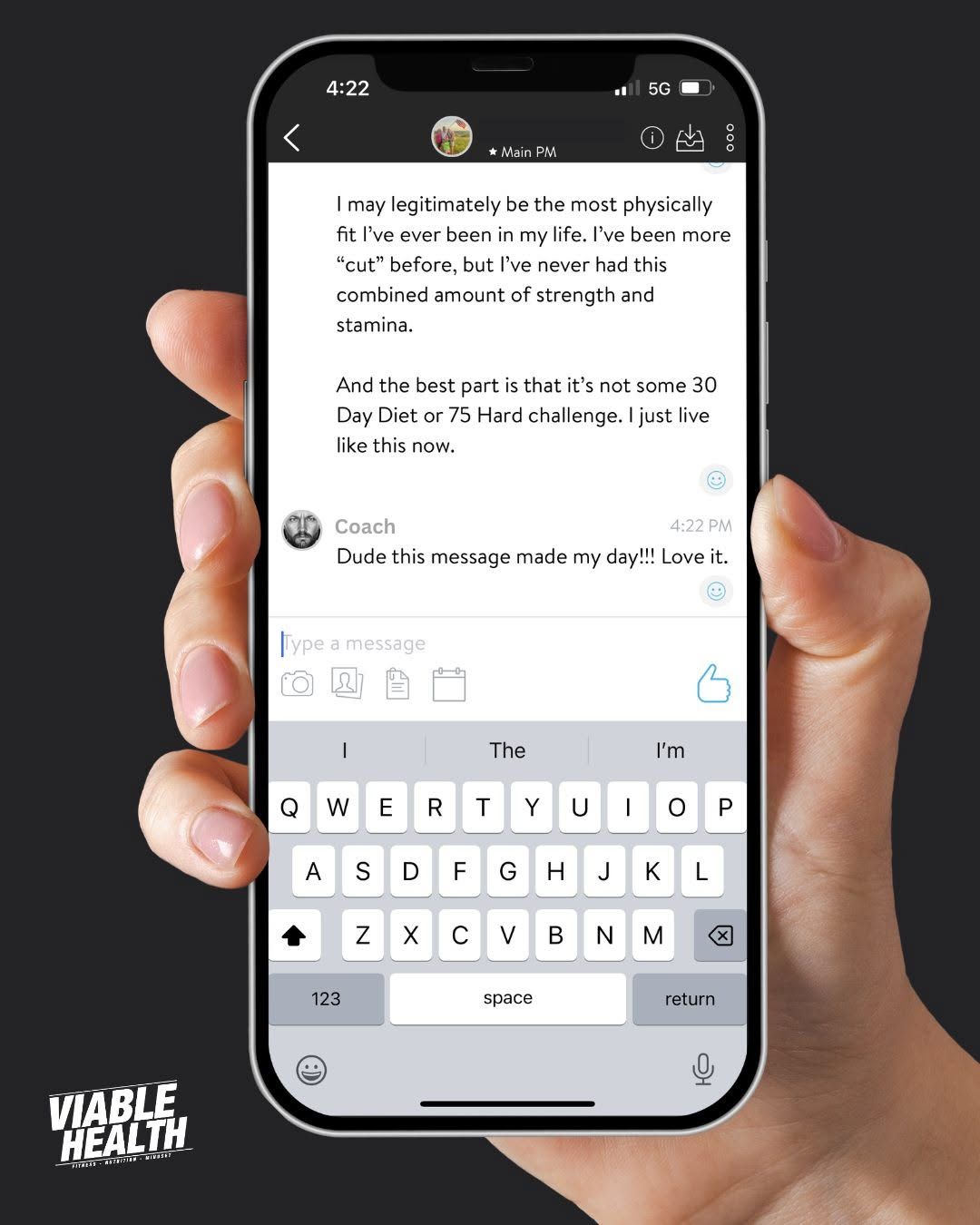 Hand holding a smartphone showing a messaging app with a typed conversation and the keyboard open