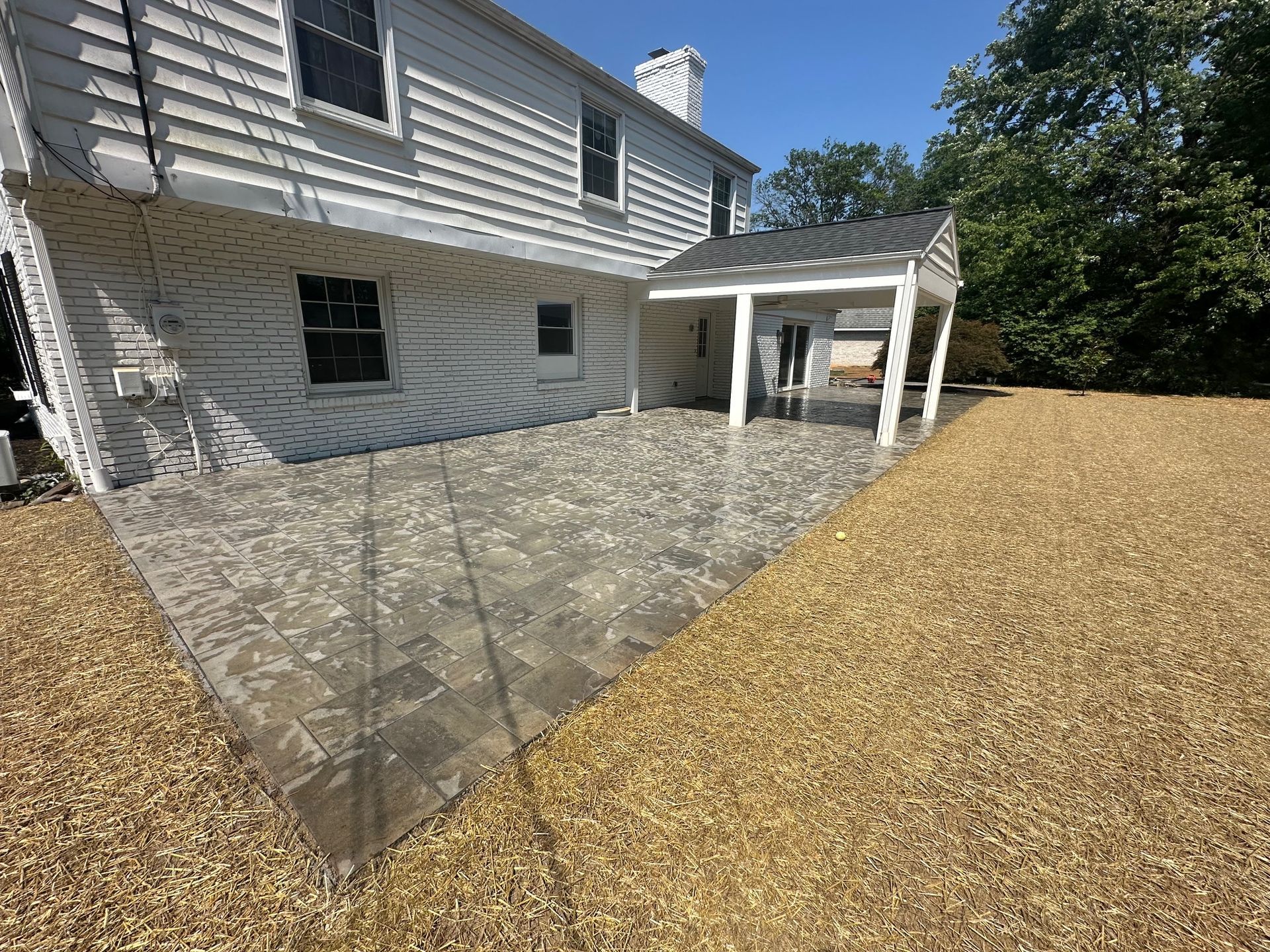 A large white house with a large patio in front of it.