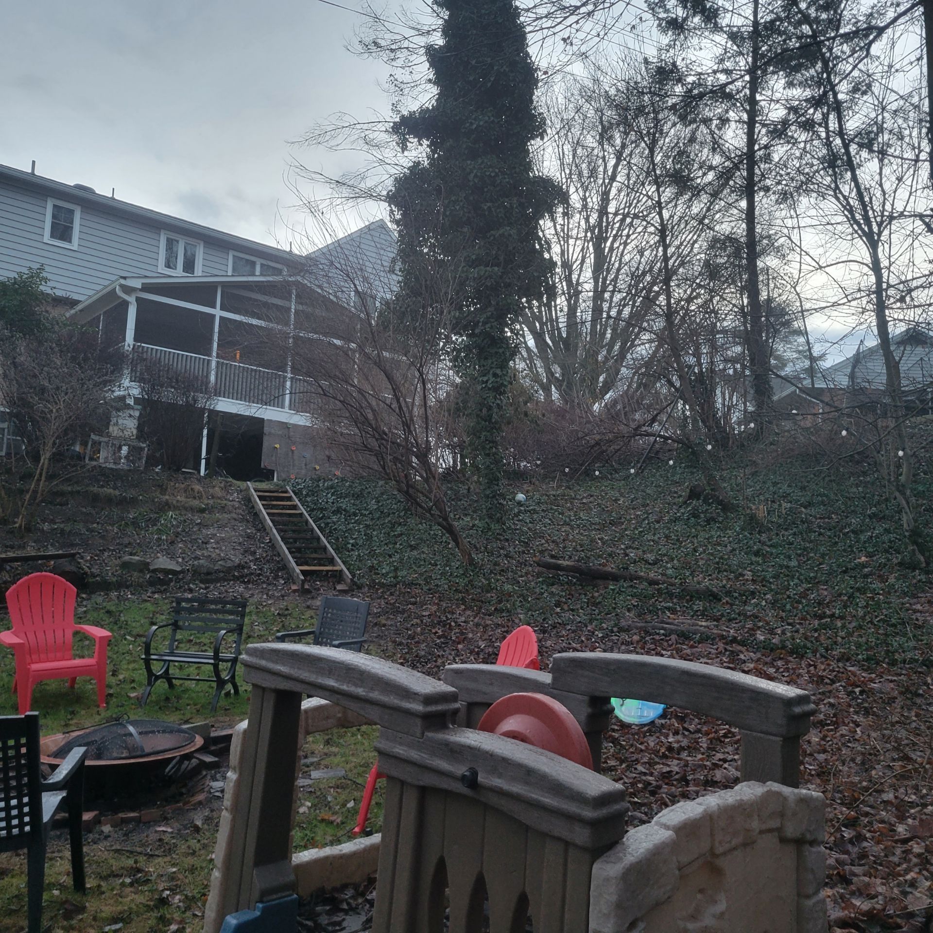 A backyard with red chairs and a fire pit