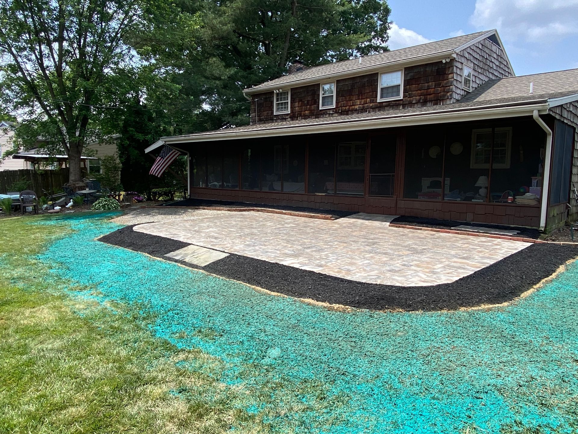 A house with a screened in porch and a patio in front of it installed by complete property solutions of Lancaster PA