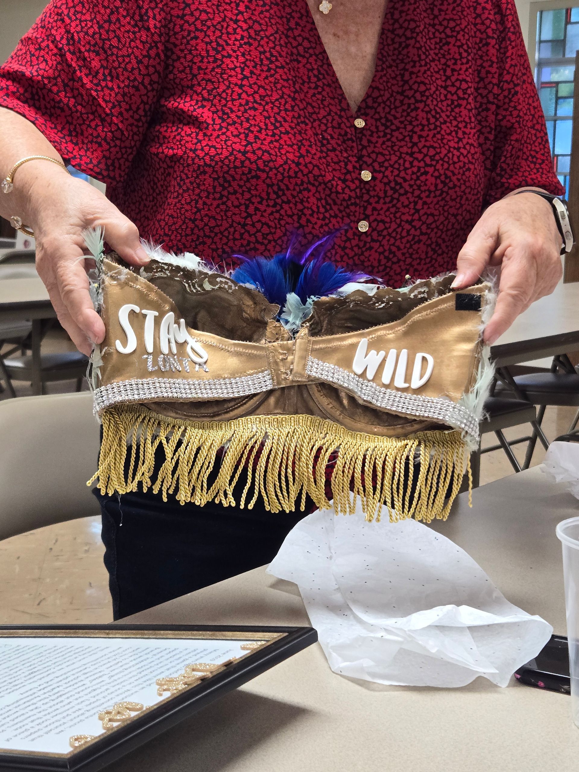 Woman holding a decorated bra with