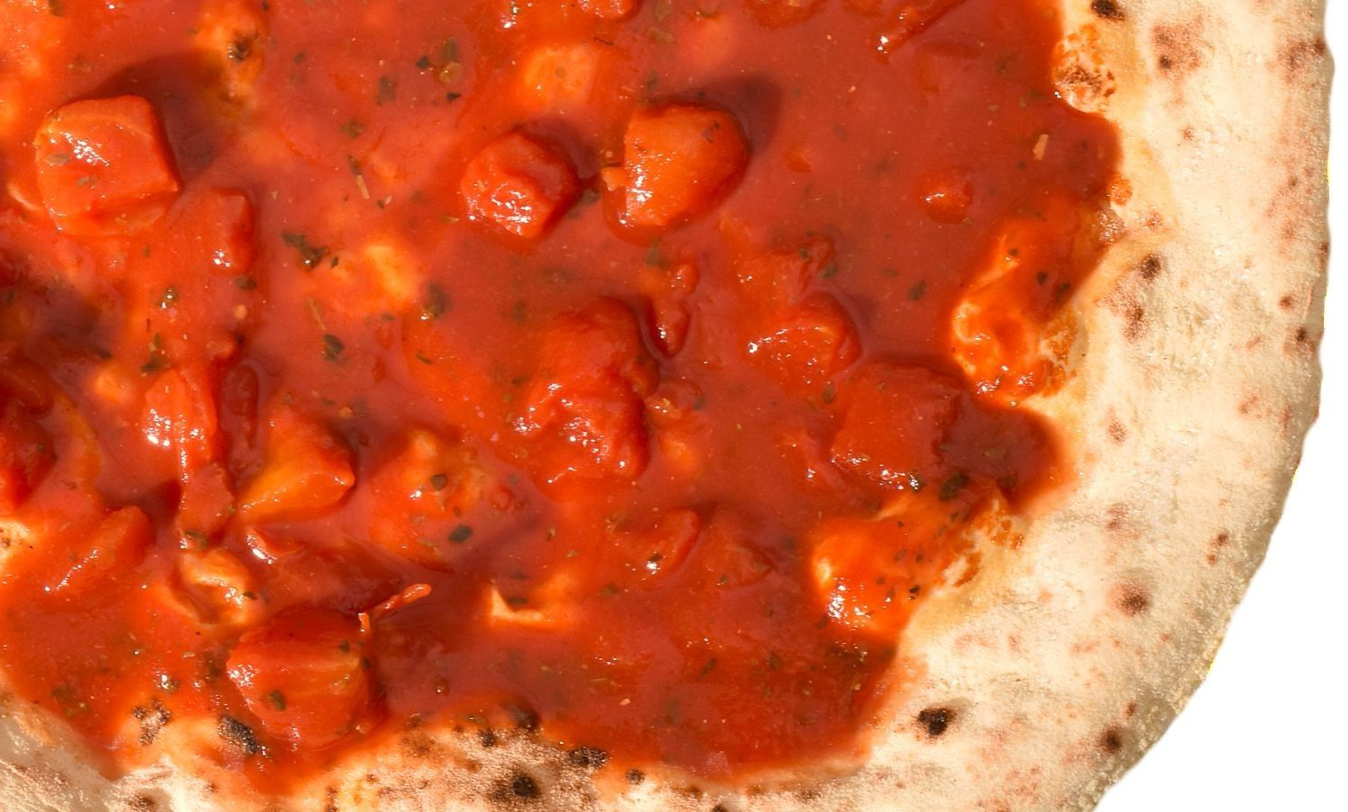 Close-up van een pizza met tomatensaus en blokjes topping op een korst.
