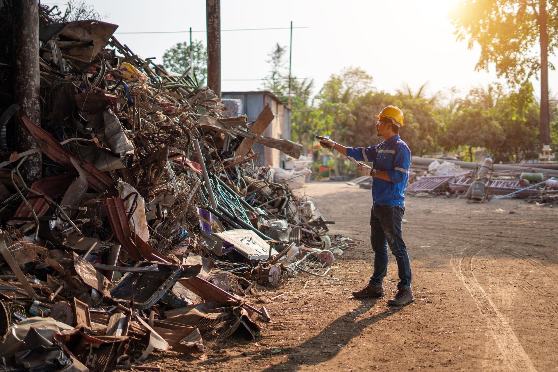 Worker sorting metal and construction waste at a recycling site during cleanup in Caboolture, Qld