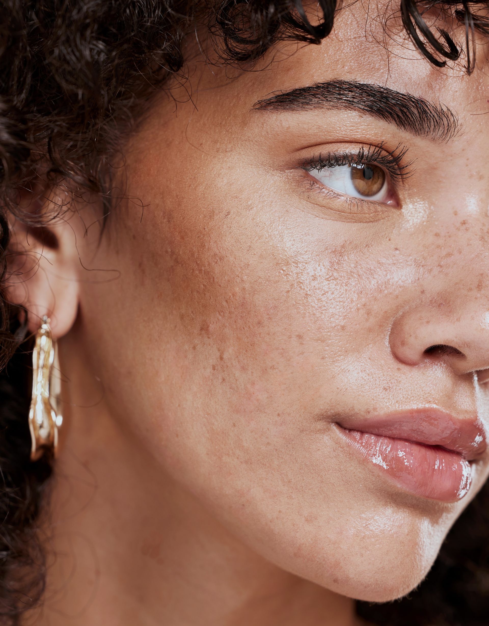 A close up of a woman 's face wearing hoop earrings.