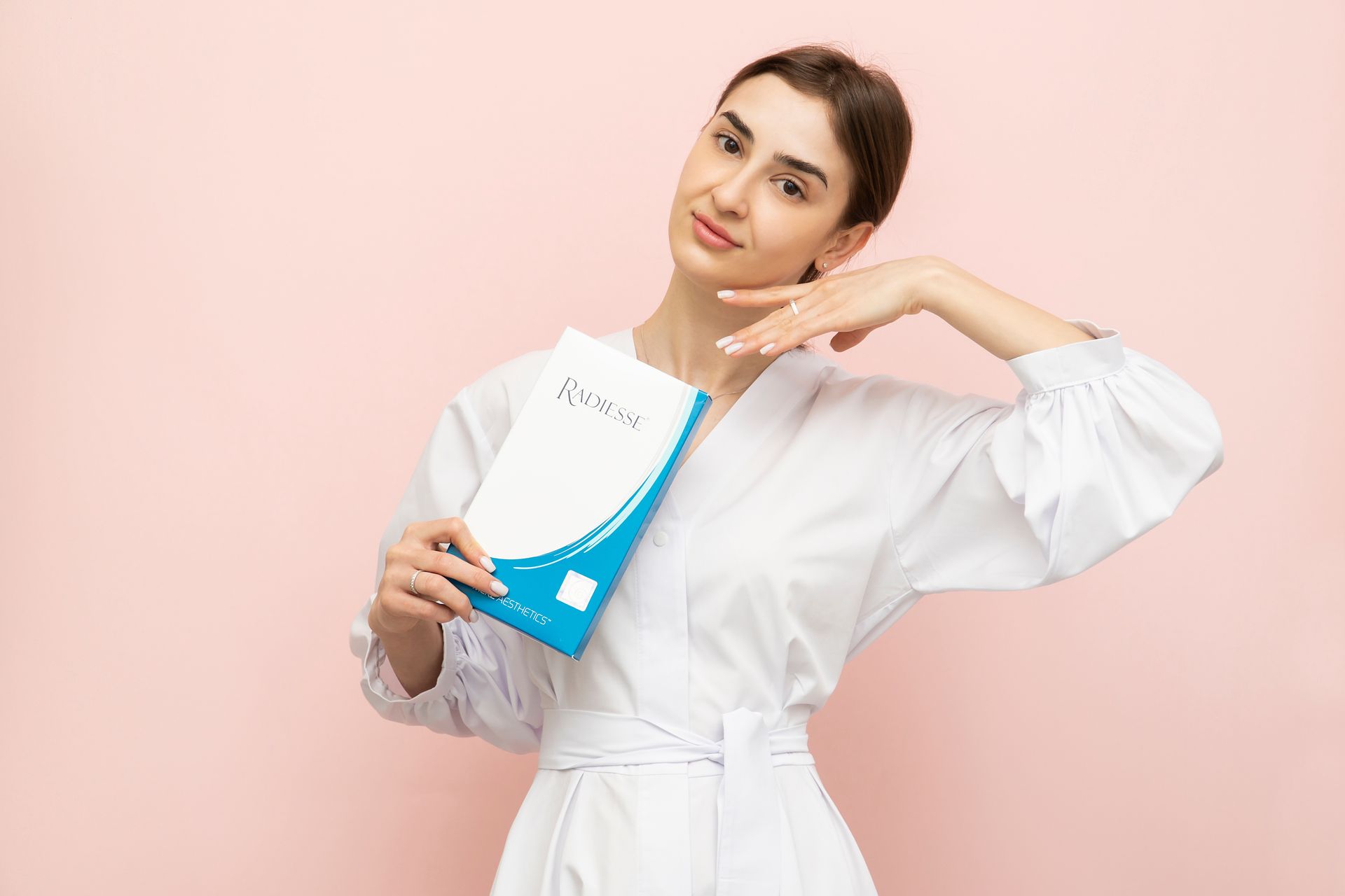 A woman in a white robe is holding a book.