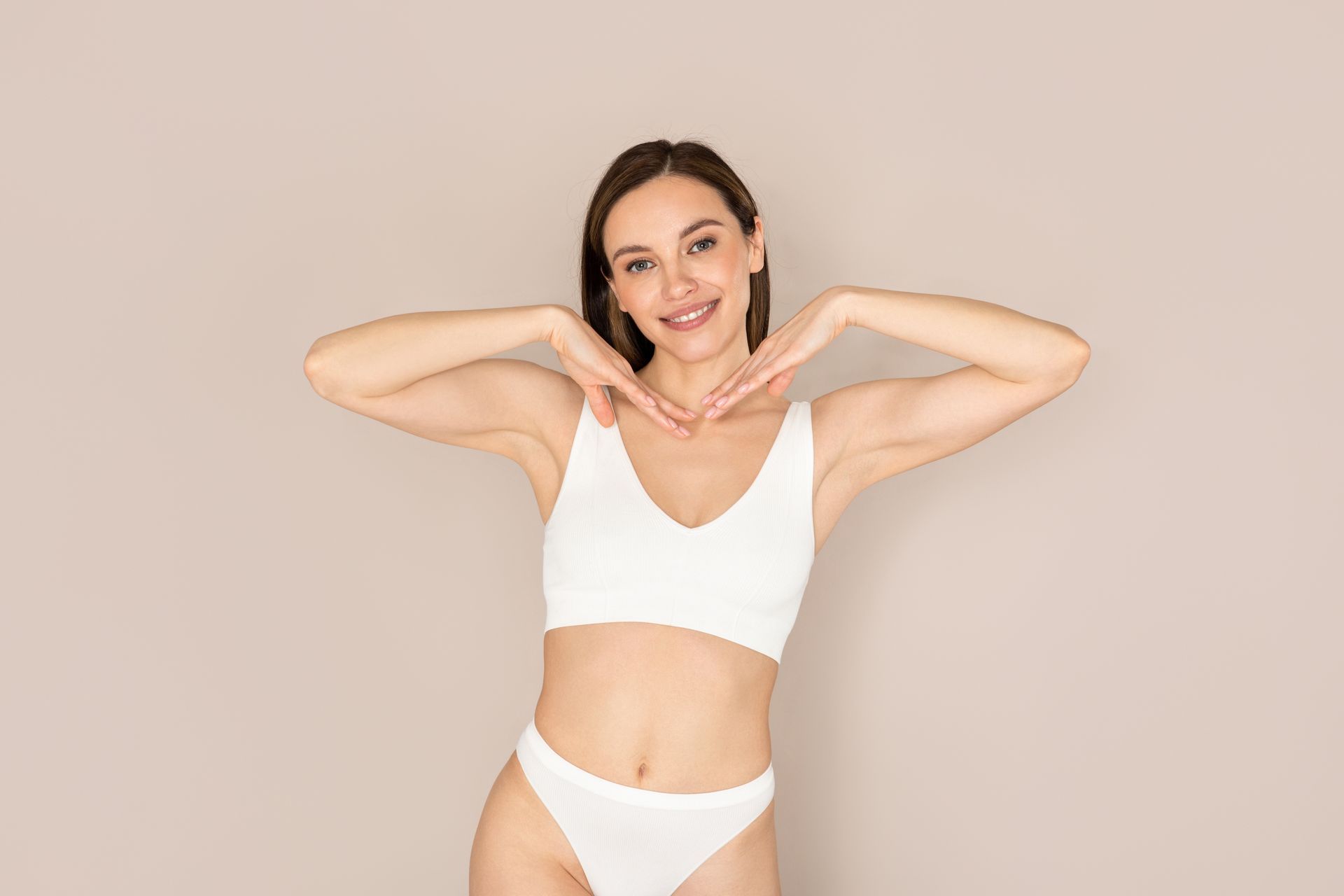 The woman is wearing white underwear and making a heart shape with her hands.