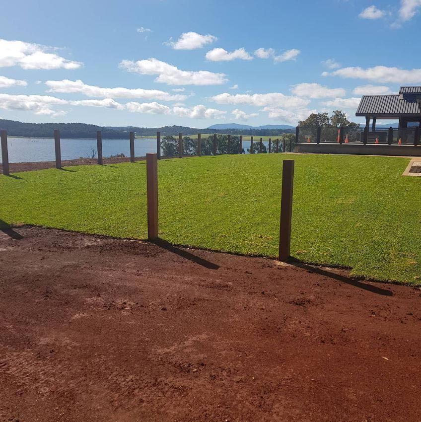 A Fence Surrounds A Lush Green Field — Barron River Lawns In Biboohra, QLD