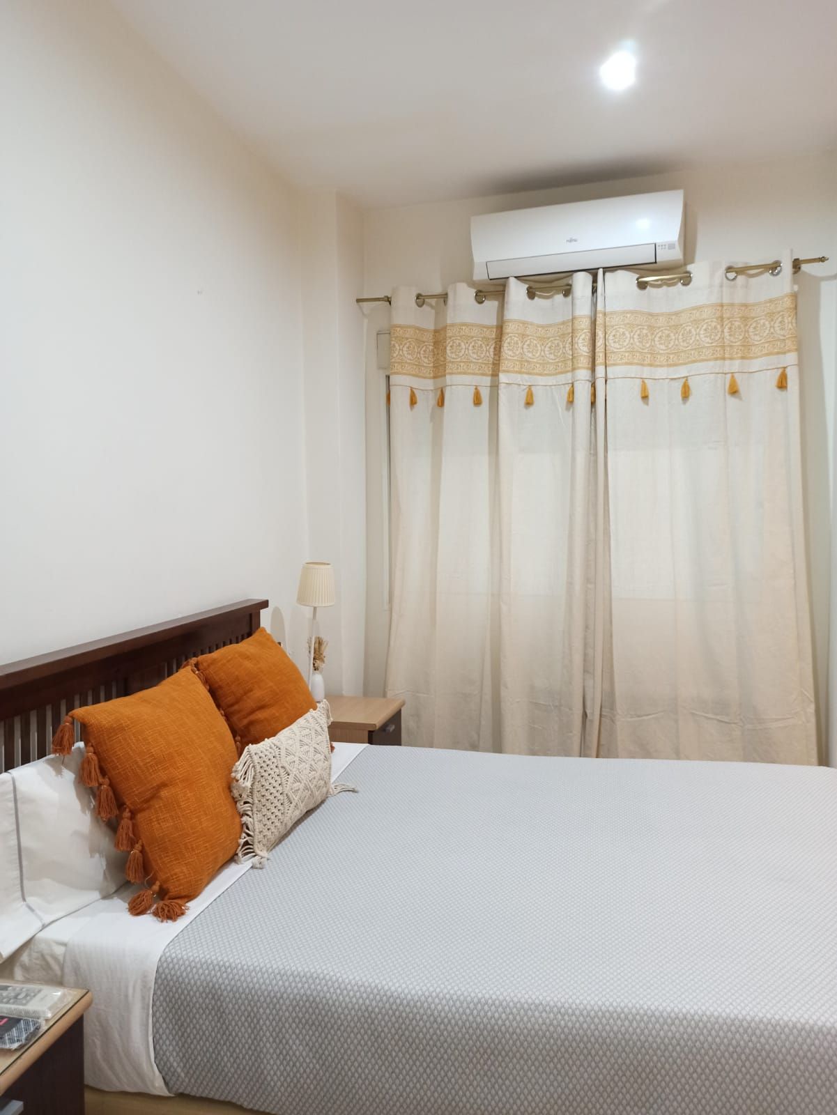 A bedroom with a king size bed and white curtains