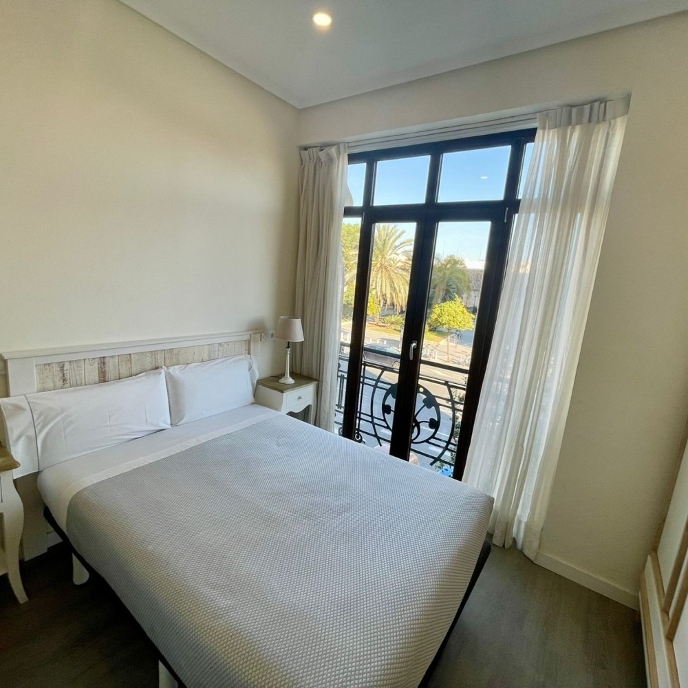 A hotel room with a large bed and a balcony