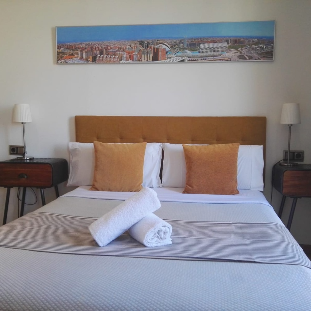 A bed with a picture on the wall above it