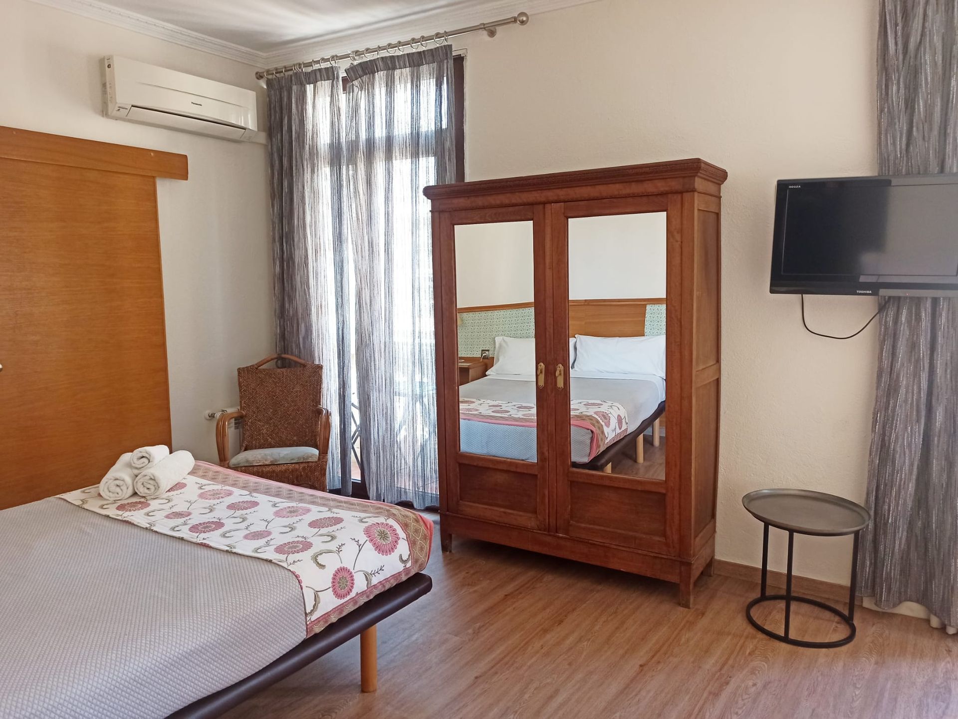 A bedroom with a bed , wardrobe , and television.