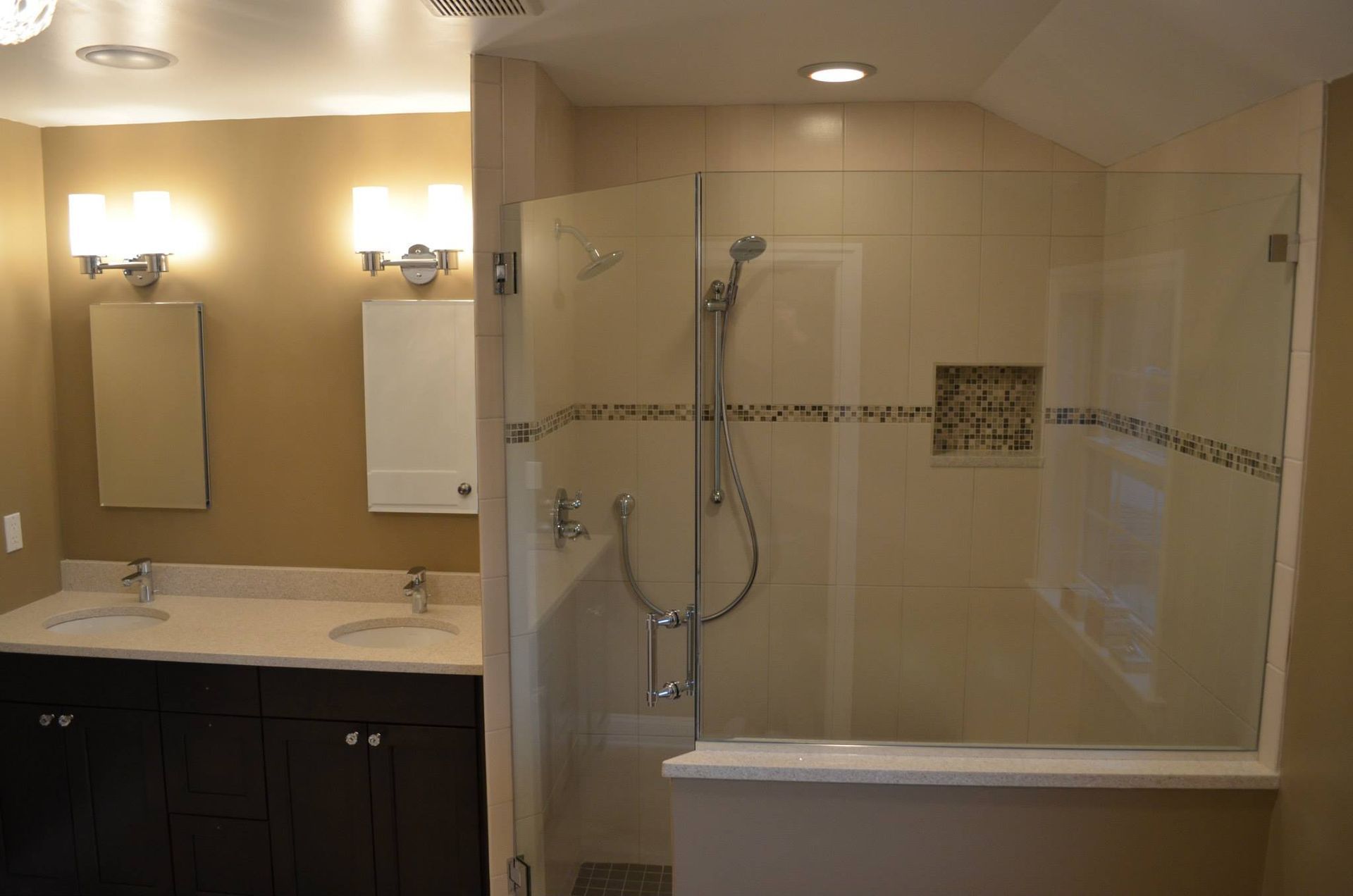 A bathroom with two sinks and a walk in shower.