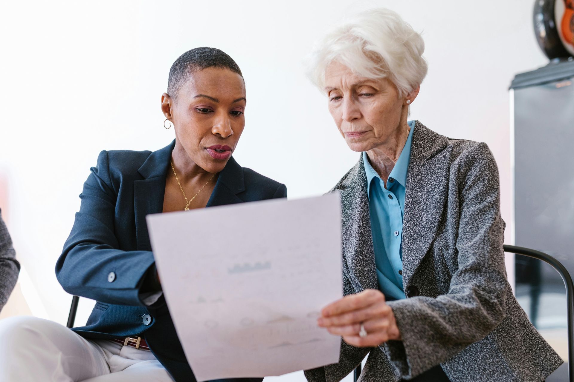 Doctor in lab coat consults with patient seated on an exam table.