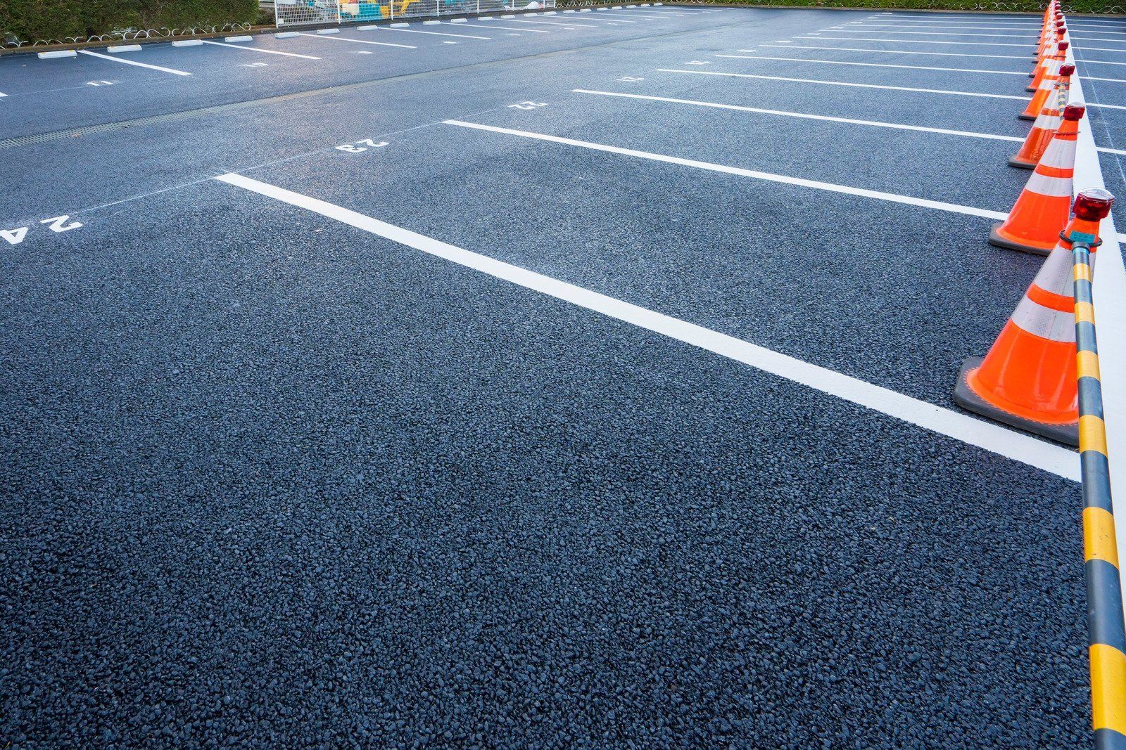Parking lot with white lines, orange cones, and dark asphalt.