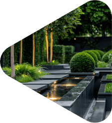 Modern landscaped garden with geometric hedges, water feature, and stone pathways