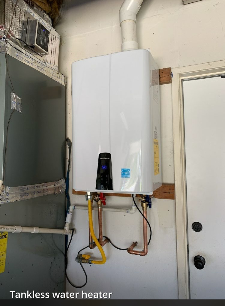 A tankless water heater is hanging on a wall next to a door.
