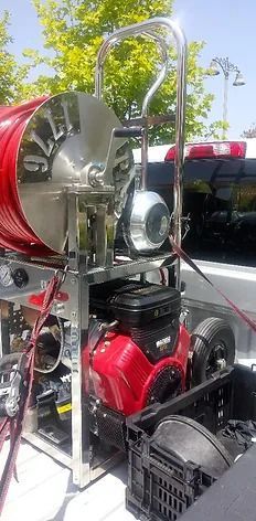 A red lawn mower is parked in the back of a truck.