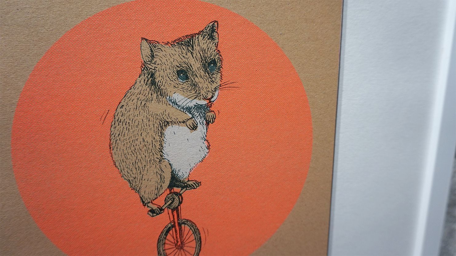 Hamster fährt Einrad, mit einem orangenen Kreis im Hintergrund.