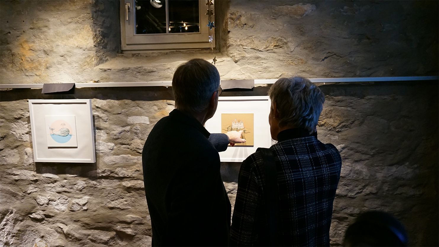 Schaumkrone Auf dem Foto sind eine Frau und ein Mann von hinten zu sehen, die bei der Ausstellung ein Bild betrachten, auf der zwei Biergläser mit Schaumkronen abgebildet sind..