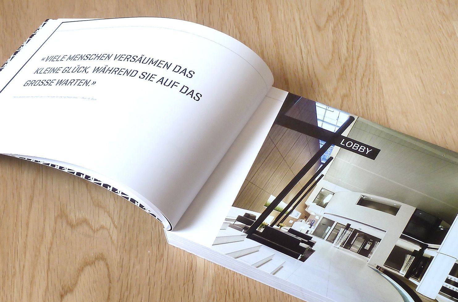 Innenseitenbeispiel aus dem Portfolio-Buch Innenseite des Portfolio-Buches mit einem Zitat und einem Foto aus einer Lobby.